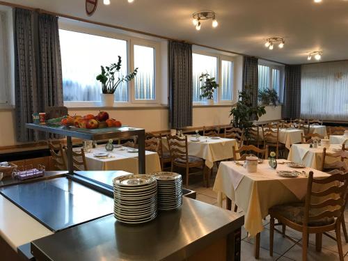 ein Esszimmer mit Tischen, Stühlen und Fenstern in der Unterkunft Hotel Marienhof Düsseldorf Neuss in Neuss