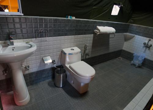 a bathroom with a toilet and a sink at Jungle Stays in Chail