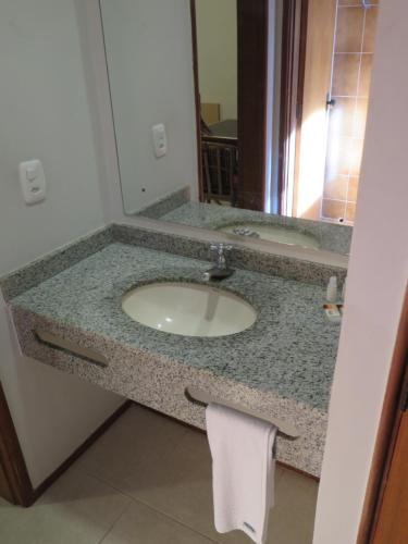 a bathroom counter with a sink and a mirror at Hotel Ideal in Londrina