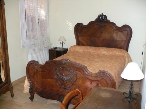 a bedroom with a large wooden bed in a room at Auberge La Pignata in Montélimar
