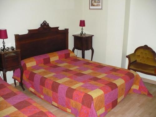a bedroom with a bed with a colorful comforter at Auberge La Pignata in Montélimar