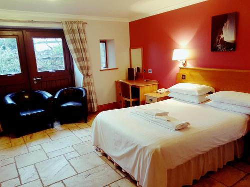 a hotel room with a bed and a chair at King's Head Inn in Llangennith