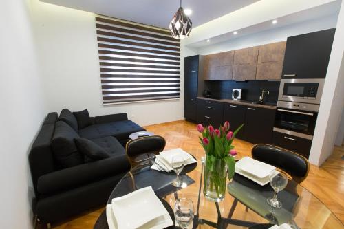 a living room with a black couch and a table at Villa Domina in Split