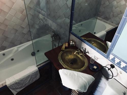 une salle de bain avec un lavabo, un miroir et une baignoire dans l'établissement Carmen De La Candelaria, à Grenade