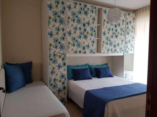 1 dormitorio con 2 camas en azul y blanco en Appartamento Vacanza Gliaca en Piraino