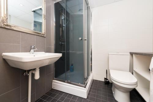 een badkamer met een douche, een wastafel en een toilet bij Telliskivi apartment 16 in Tallinn