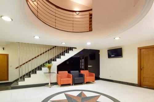 un vestíbulo con sillas naranjas y una escalera de caracol en Pensión Txiki Polit, en Zarautz