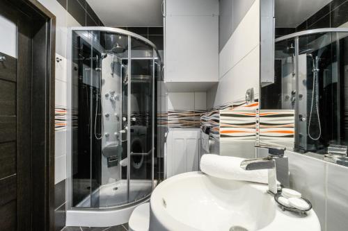 W łazience znajduje się biała umywalka i prysznic. w obiekcie P&O Serviced Apartments GOCLAW w Warszawie