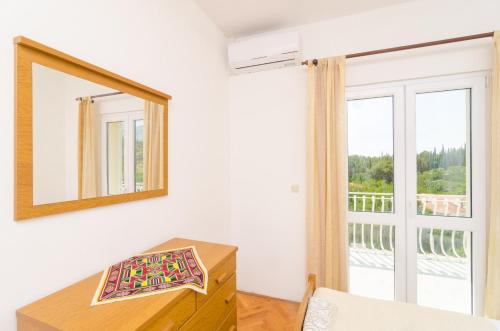 a room with a mirror and a dresser and a window at Villa Dalmatian Gem in Gruda