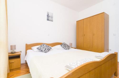 a bedroom with a large bed with a wooden cabinet at Villa Dalmatian Gem in Gruda