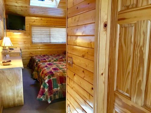 a bedroom with a bed in a log cabin at Giant Oaks Lodge in Running Springs