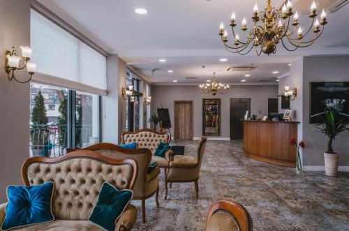 a lobby with couches and chairs and a chandelier at Hotel Paryski Art & Business Zakopane - Basen Jacuzzi Sauna Małpi Gaj in Zakopane
