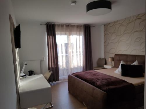 a hotel room with a bed and a window at Aparthotel Magnolia in Oberursel
