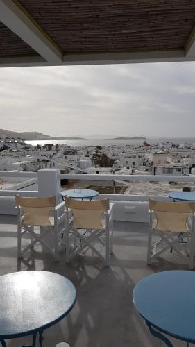 a patio with tables and chairs and a view of a city at Lefteris in Mýkonos City