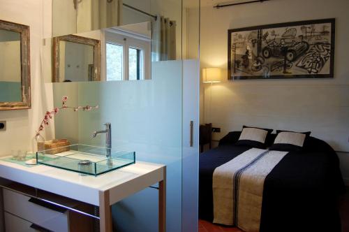 1 dormitorio con 1 cama y lavamanos con espejo en Finca Bell-Lloc en Palamós