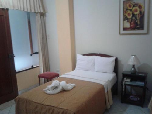 a hotel room with a bed with a towel on it at Hotel Plaza Bolognesi 344 in Trujillo