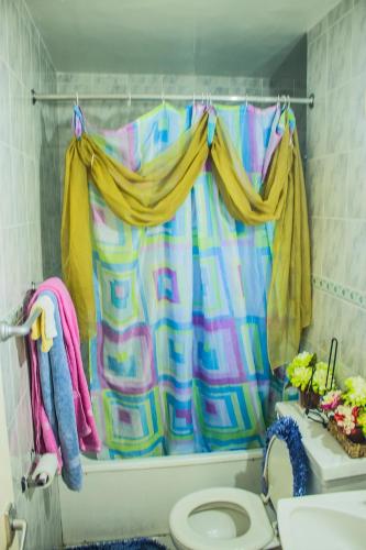 a bathroom with a shower curtain and a toilet at Turtle Beach Towers in Ocho Rios