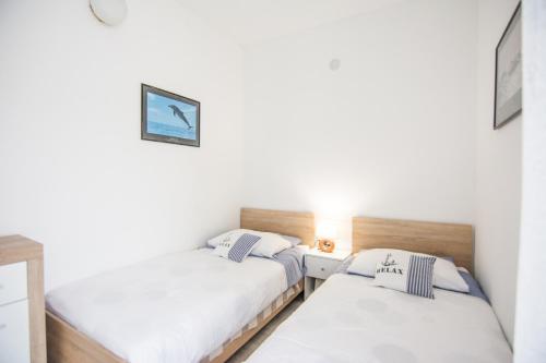 2 letti in una piccola camera con pareti bianche di Apartment Sali Dugi Otok a Sali (Sale)