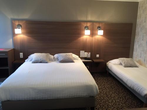 a hotel room with two beds and two lights at Le Galion Hotel et Restaurant Canet Plage - Logis in Canet-en-Roussillon