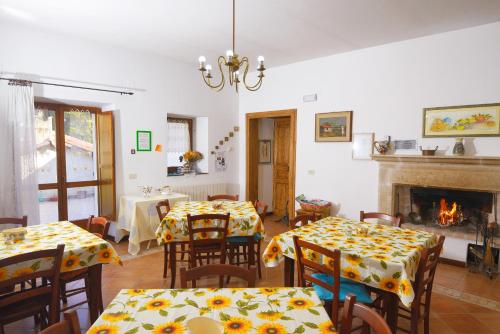 een eetkamer met 2 tafels en een open haard bij Bed & Breakfast De Contra in Villetta Barrea