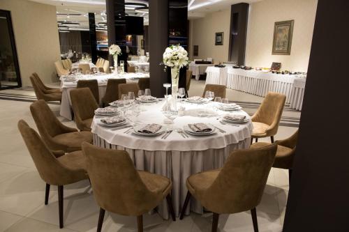 a long table with chairs and a white table cloth at Hotel Ideo Lux in Niš