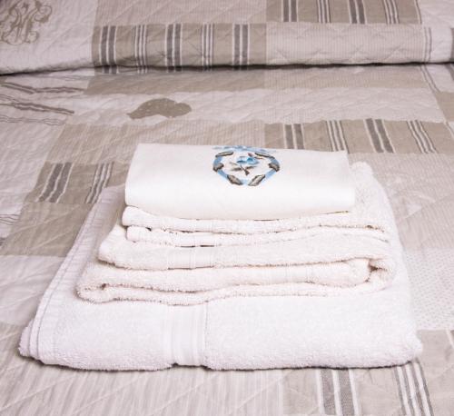 una pila de toallas sentadas en una cama en La Casetta B&B en Cernusco sul Naviglio