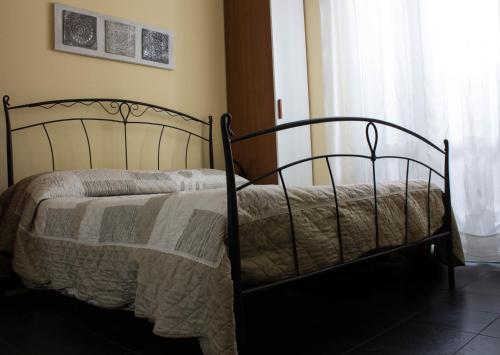 una camera da letto con un letto con una coperta e una finestra di La Casetta B&B a Cernusco sul Naviglio