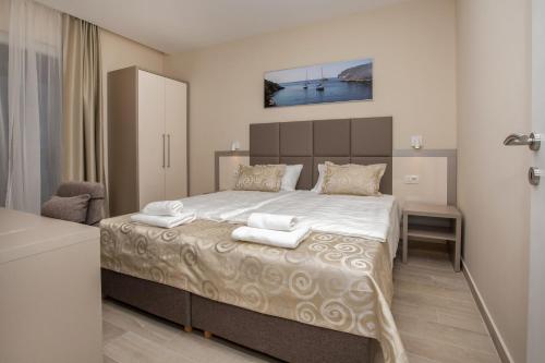 een slaapkamer met een groot bed met handdoeken erop bij Villa Marijola in Lovište