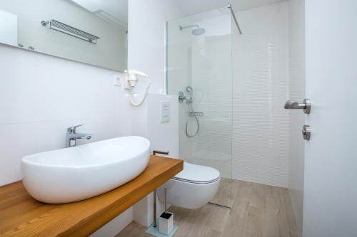 een witte badkamer met een wastafel en een toilet bij Villa Marijola in Lovište