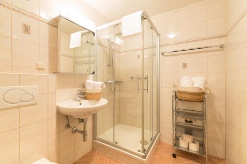 a bathroom with a glass shower and a sink at Appartement Roland in Strobl