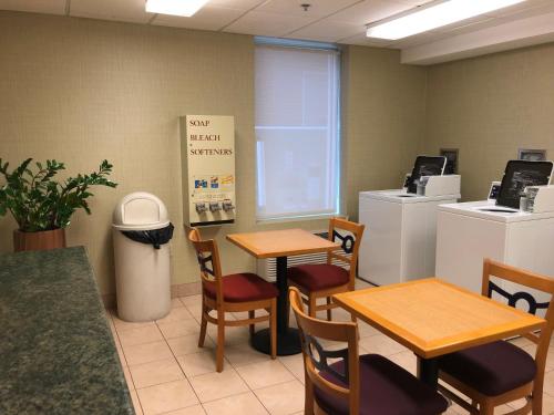 a restaurant with two tables and chairs and a trash can at Wyndham Garden Buffalo Downtown in Buffalo