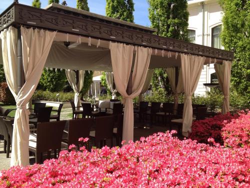 a gazebo in a garden with pink flowers at Grand Visconti Palace in Milan