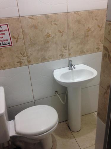 a bathroom with a toilet and a sink at Hotel Florêncio in São Paulo