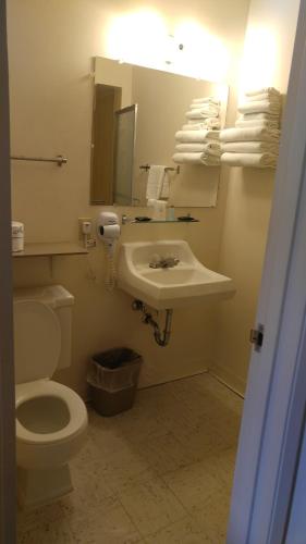 a bathroom with a sink and a toilet and a mirror at Americas Best Value Inn North Platte in North Platte
