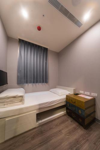a bedroom with a large bed and a window at Skyone Hotel in Kaohsiung
