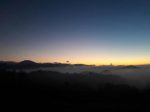 a view of a foggy valley at sunset at Ötscherblick Fam Winter in Frankenfels