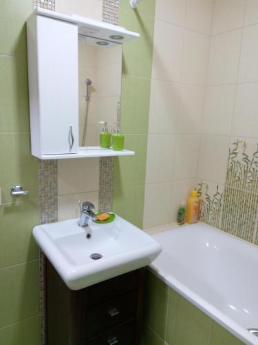 ein Badezimmer mit einem weißen Waschbecken und einer Badewanne in der Unterkunft Two-bedroom apartment in the center in Chmelnyzkyj