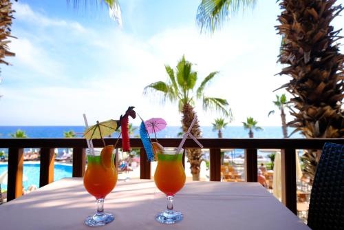 two cocktails on a table on a balcony with the beach at Anitas Hotel in Konaklı