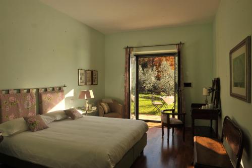 a bedroom with a bed and a sliding glass door at Chiusa della Vasca in Castelnuovo di Farfa