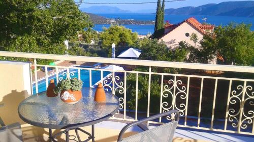 a table on a balcony with a view of the water at Maisonette Ilios in Korfos