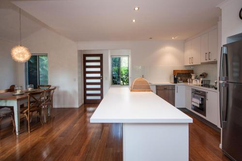 a kitchen and dining room with a white counter top at Barbados Noosa in Noosaville