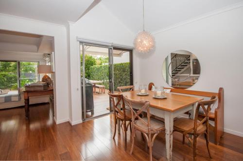 a dining room with a table and chairs at Barbados Noosa in Noosaville
