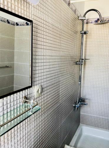 a bathroom with a shower and a mirror and a tub at El Muniria in Tangier
