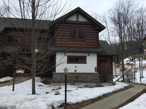a house with snow in front of it at Boyne Mountain Creekside Condo in Boyne Falls
