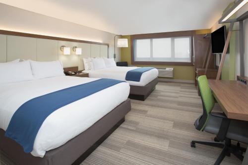 a hotel room with two beds and a desk at Holiday Inn Express & Suites Nashville North - Springfield, an IHG Hotel in Springfield