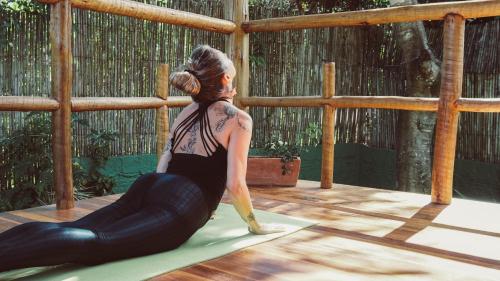 a woman doing yoga on a yoga mat at Casa da Lua Pousada in Alto Paraíso de Goiás