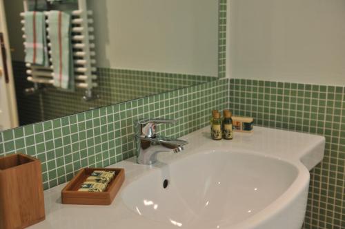 a bathroom with a sink and a green tiled wall at Chiusa della Vasca in Castelnuovo di Farfa