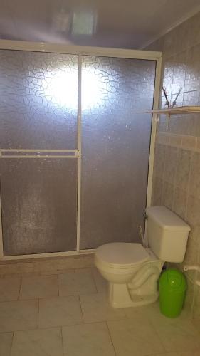 a bathroom with a toilet and a glass shower door at Miss Leila in San Andrés