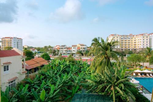 a view of a city with palm trees and a pool at B'Lan Riverside Villa in Hoi An