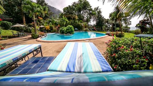 a pool with two blue and white surfboards in a yard at Hotel San Buenaventura de Atitlán in Panajachel